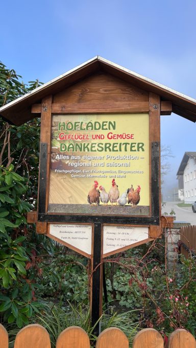Holzschnitt mit dem Text „Hofladen: Eier und Geflügel“ sowie drei Hühnern.